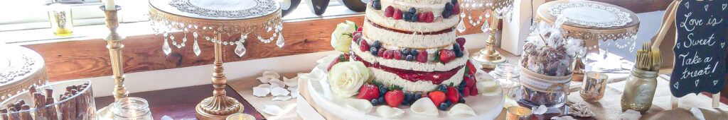 Table with wedding cake covered in strawberries, blueberries and raspberries